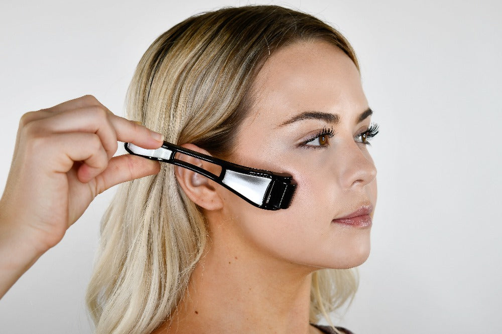 side on picture of a lady using a dermaroller on her face